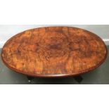 A marquetry and burr walnut oval coffee table on four carved cabriole legs and casters, 102x65x36cmH