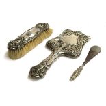 An Early 20th century chased silver hand mirror, with bevelled shaped plate; together with clothes