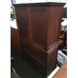 A 20th century oak linen press, cupboard doors with shelves, over an arrangement of two long