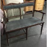 An Edwardian double seat, with spindle turned back, upholstered seat, some damage, 112cmW