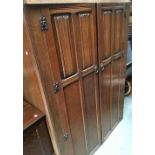 A 20th century oak wardrobe enclosed by linen fold doors, 124x56x186cmH