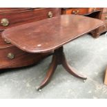 A rectangular side table on column base and three swept legs, with brass caps and casters, 106cmW