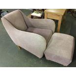 A contemporary deep armchair, with matching footstool