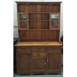 A 20th century oak dresser, the top with shelves and glazed doors, over three drawers with three