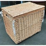 A wicker laundry basket, fabric lined, on casters, 60x41x57cmH
