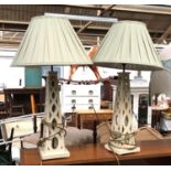 A pair of contemporary white painted pierced wooden table lamps, of tapering form, each with pale