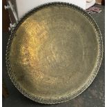 A large brass Islamic tray, engraved with various patterns and figural scenes, 73cmD