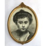 A 19th century charcoal sketch of a young boy in tam o'shanter, in an oval frame
