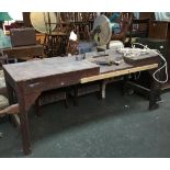A large solid workbench, with makita mitre saw attached, one side with casters, the other with