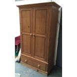 A pine hanging wardrobe, two doors over single drawer, 121x66x209cmH