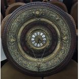 A brass clock, enamel dial with Roman numerals, set within a concentric brass and carved wood