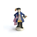 A small Chelsea figurine of a continental gentleman with horn, heightened in gilt, gold anchor