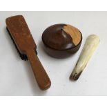A treenware lidded box, bone shoehorn, and a clothes brush