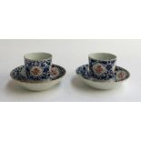 A pair of Chinese blue and white teacups and saucers, decorated with pink floral panels, the cups