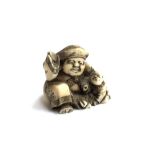 A small Meiji era Japanese ivory netsuke depicting a man and two infants (af), 4cmH