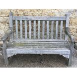 A solid garden bench with slat back and seat, 137cm wide