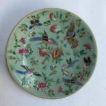 A Chinese famille verte plate, decorated with images of birds and butterflies, on celadon ground,