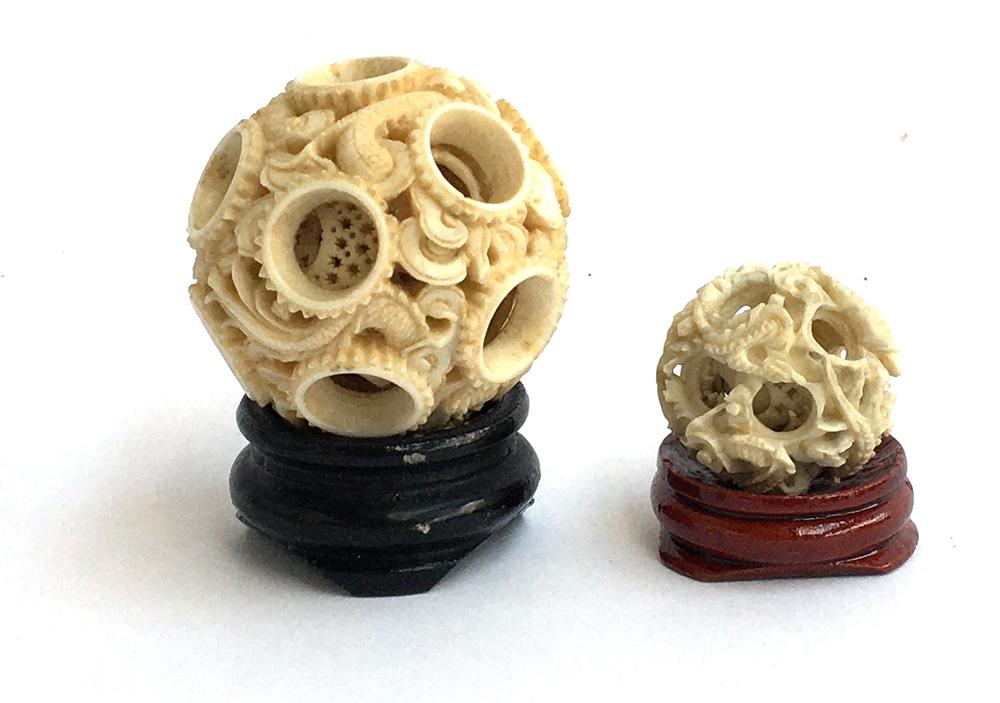 Two Chinese carved ivory concentric puzzle balls, each depicting dragons, the larger approx. 5cmD, t