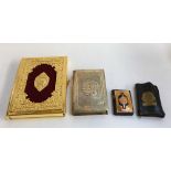 Two highly decorative Qurans, one in white metal sleeve; with two others