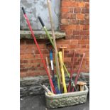 A good selection of garden tools in a composite stone planter, the planter 71cmL