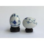 A pair of Bing & Grondahl blue and white porcelain eggs, marked to base 691 and 692, with hardwood