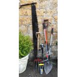 A mixed lot of tools comprising garden forks, shovel, clippers, two handled bow saw, etc