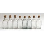 A lot of 8 square glass bottles with cork stoppers, each 18cmH
