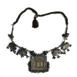 A Laotian white metal necklace, with central picture panel