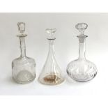 Three glass decanters, one engraved, with stoppers