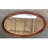 An oval mahogany and inlay mirror with bevelled glass, 75cmW