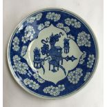 A blue and white Chinese export plate, with floral decoration surrounding central images of urns,