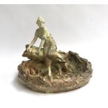 A German Art Nouveau porcelain woman, depicted sitting on a log, 27cmH