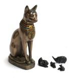An Egyptian style cat figurine, 31cmH; together with three small cat figures and a carved stone