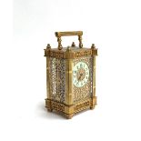 A gilt metal mantel clock, pierced scrolling sides, the enamel dial surrounded by scrolling