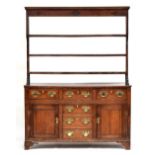 A George III oak welsh dresser, the top with three shelves, over a base of three drawers over a