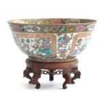 A large 19th century Chinese famille rose punch bowl, depicting four panels of flora and fauna