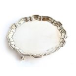 A silver salver by Viners, Sheffield 1938, of shaped circular form with pie-crust rim raised upon