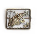 A c.1940s Georg Jensen sterling silver brooch featuring two dolphins designed by Arno Malinowski,