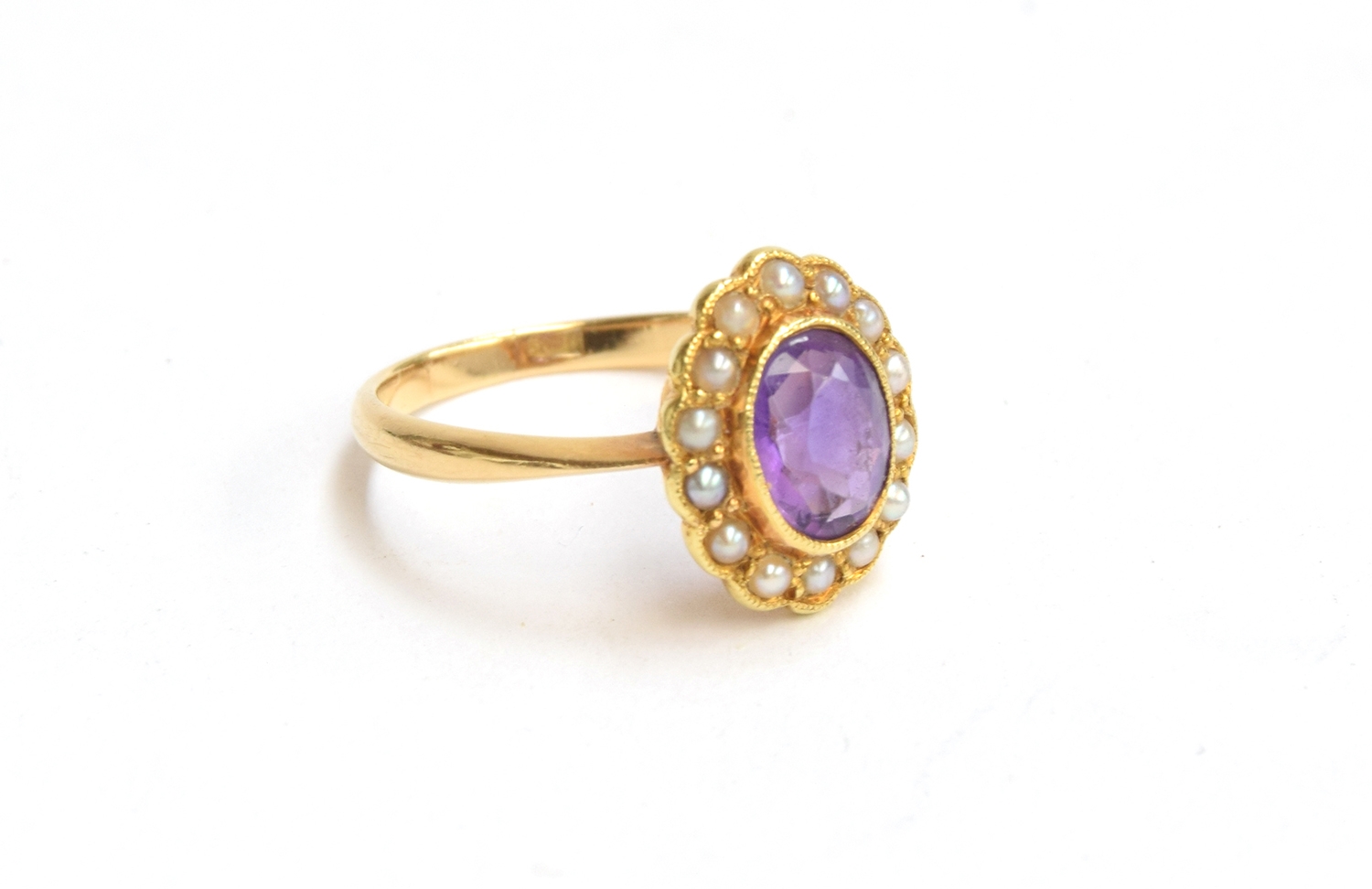 An 18ct gold seed pearl and amethyst ring, gross weight 3.8g, size M