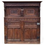 A 17th century joined oak court cupboard, boarded top, the upper section with turned pendants and