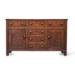 A George III oak dresser base, having three short drawers and a further three drawers flanked by