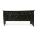 A late 17th century six plank oak coffer, having carved apotropaic symbols, , 108cm wide, 37cm deep