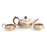 A George V silver bachelor's three piece teaset, by Harrods Ltd, London 1927, of compressed