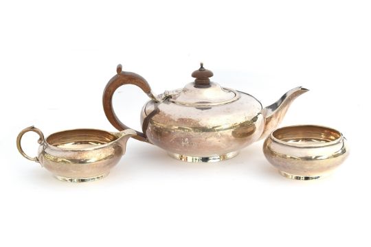 A George V silver bachelor's three piece teaset, by Harrods Ltd, London 1927, of compressed