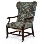 A naive early Georgian wingback open armchair, square section legs joined by peripheral