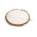 A pale jade brooch of oval form set within an unmarked gold, pierced border approx. 6 x 5cm