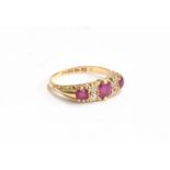 An 18ct gold dress ring set with 3 rubies and 4 small diamonds on a decorated shank, gross weight
