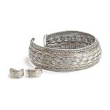 A heavy silver choker necklace with matching earrings in a woven design with gold decoration. Both