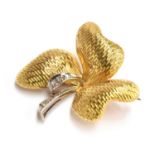 A 18ct gold brooch in the form of a clover, the stem white gold set with 6 diamonds, gross weight