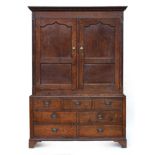 George III oak press cupboard, enclosed by panelled doors, on a base comprising three blind drawers,